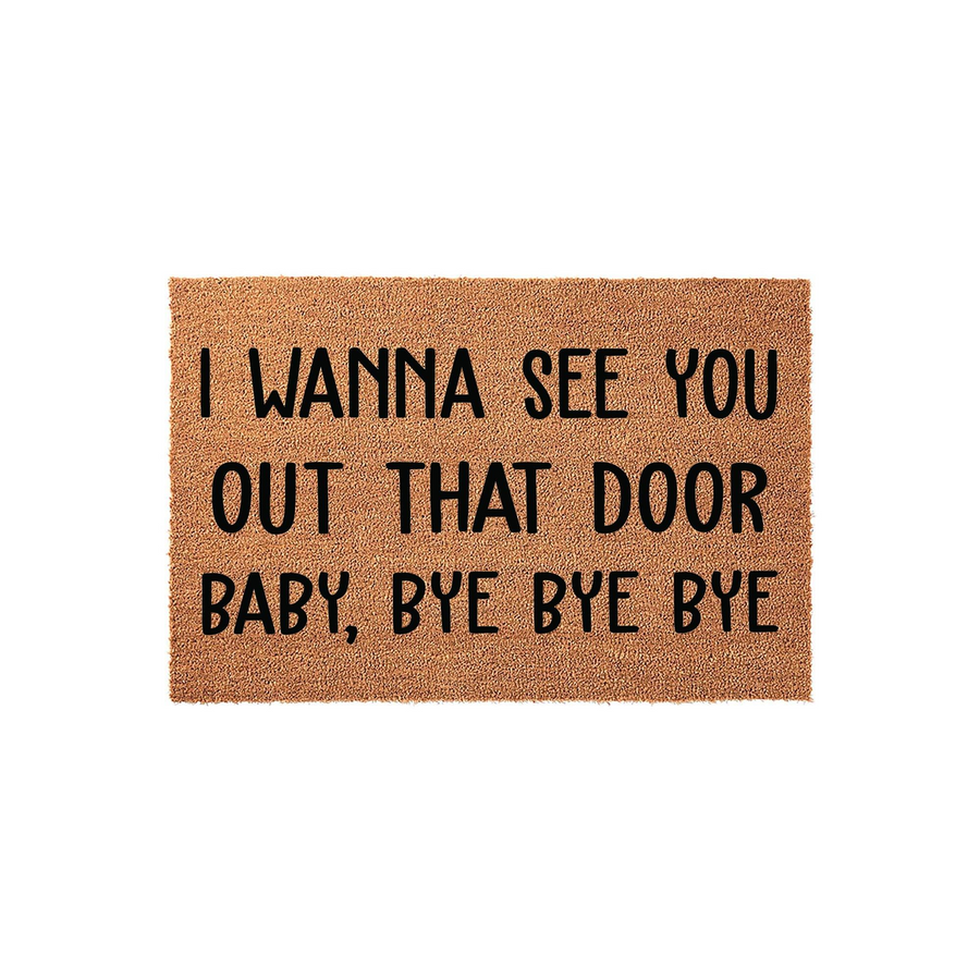 Funny music lyric doormat featuring a natural coir texture and bold black lettering that reads I wanna see you out that door baby bye bye bye, making it a humorous and welcoming entrance rug for any fan of nineties pop music.