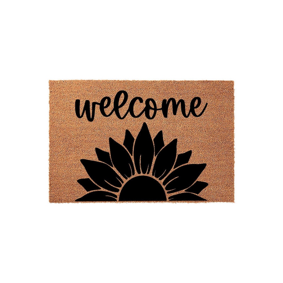 Sunflower Welcome Doormat featuring a natural coir texture with a bold black script font and a large, stylized sunflower graphic printed at the bottom, creating a cheerful and inviting entryway decor piece for your front porch.