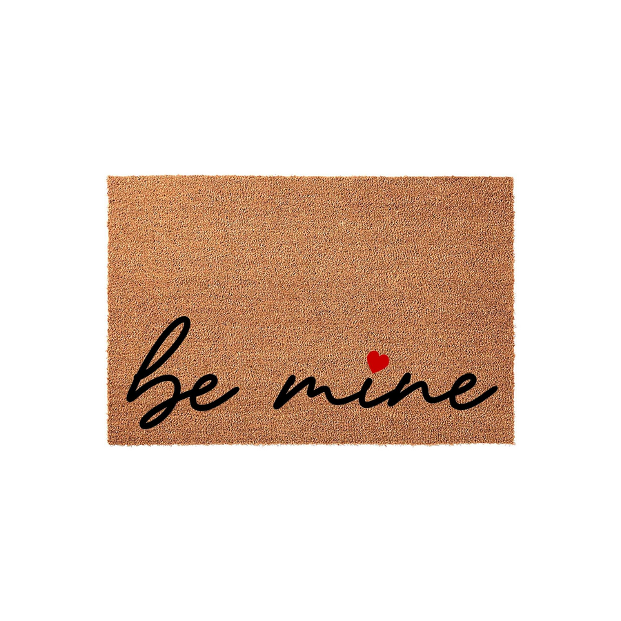 Be Mine Valentine Coir Doormat featuring natural brown coconut fiber texture with elegant black cursive script lettering and a small red heart accent, perfect for a festive entryway decoration during the romantic holiday season.
