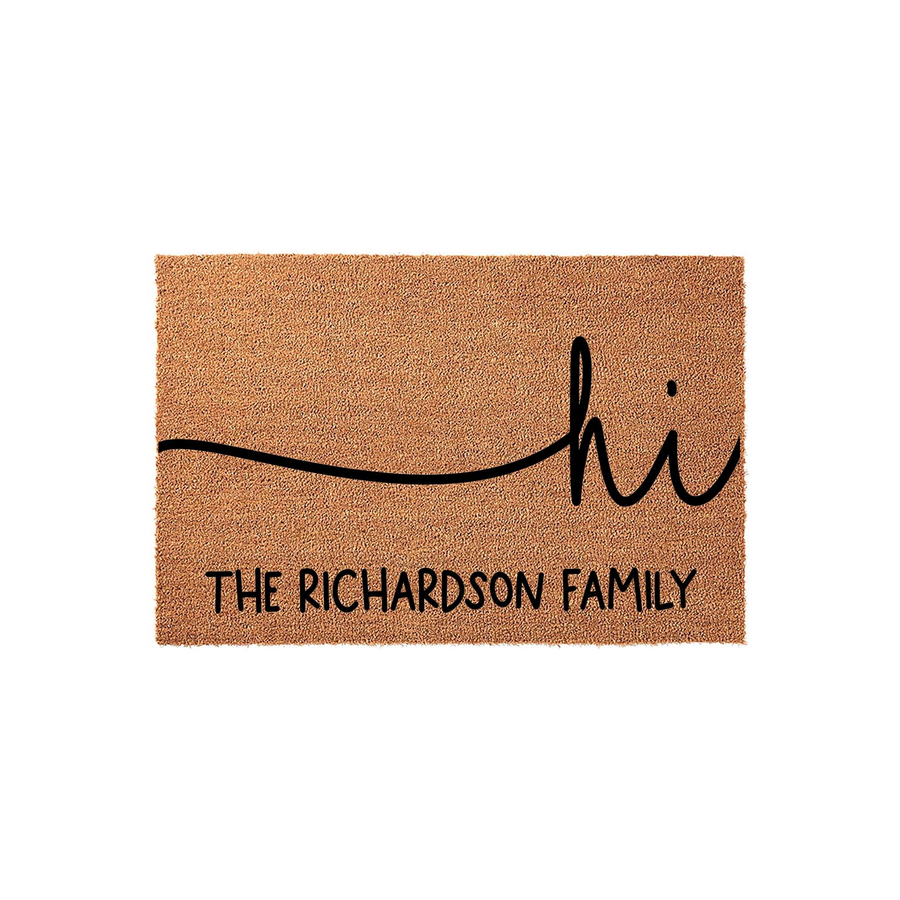 Personalized family name coir doormat featuring a minimalist black script design that says hi with a wavy line, providing a welcoming touch to any front porch entrance while showcasing a custom last name for a unique home decor