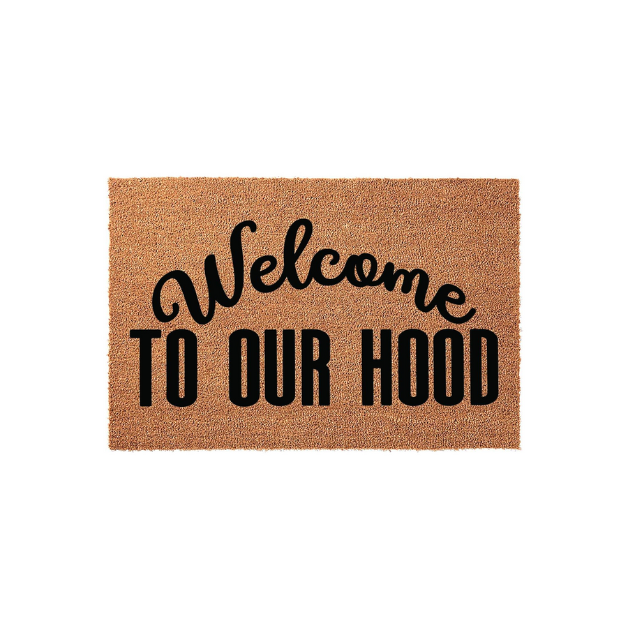 Welcome To Our Hood coir doormat featuring a natural tan fiber texture and bold black lettering, providing a fun and inviting entrance decor piece for your front porch or home entryway that greets guests with a humorous