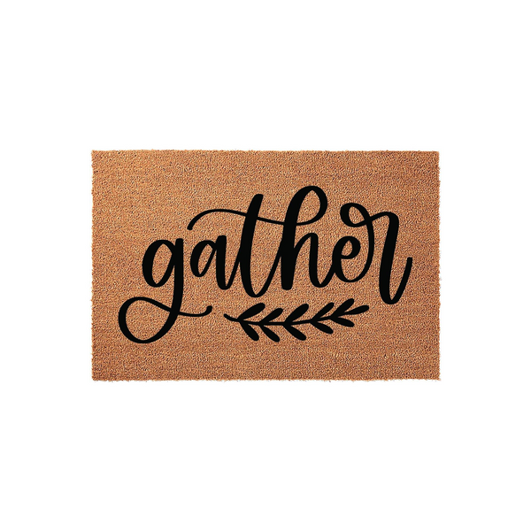 Gather coir doormat featuring a natural tan fiber texture and bold black script lettering that reads gather, accented by a simple leafy branch design, making it a welcoming addition to any front porch or entryway decor.