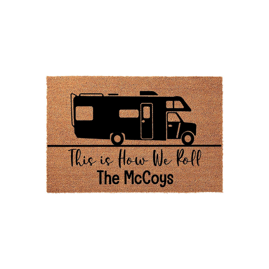 Personalized Camper Doormat featuring a black silhouette of a recreational vehicle above the text This is How We Roll and a customizable family name, set against a natural brown coir fiber background for a rustic outdoor entryway