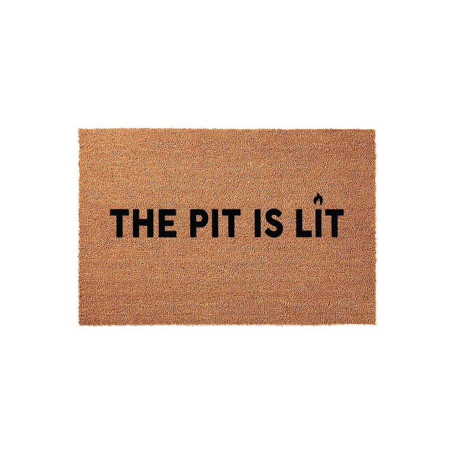 The Pit Is Lit funny outdoor doormat made of natural coir fiber with a durable backing, featuring bold black text and a small flame icon centered on a plain white background for a clean, modern entryway decor look.