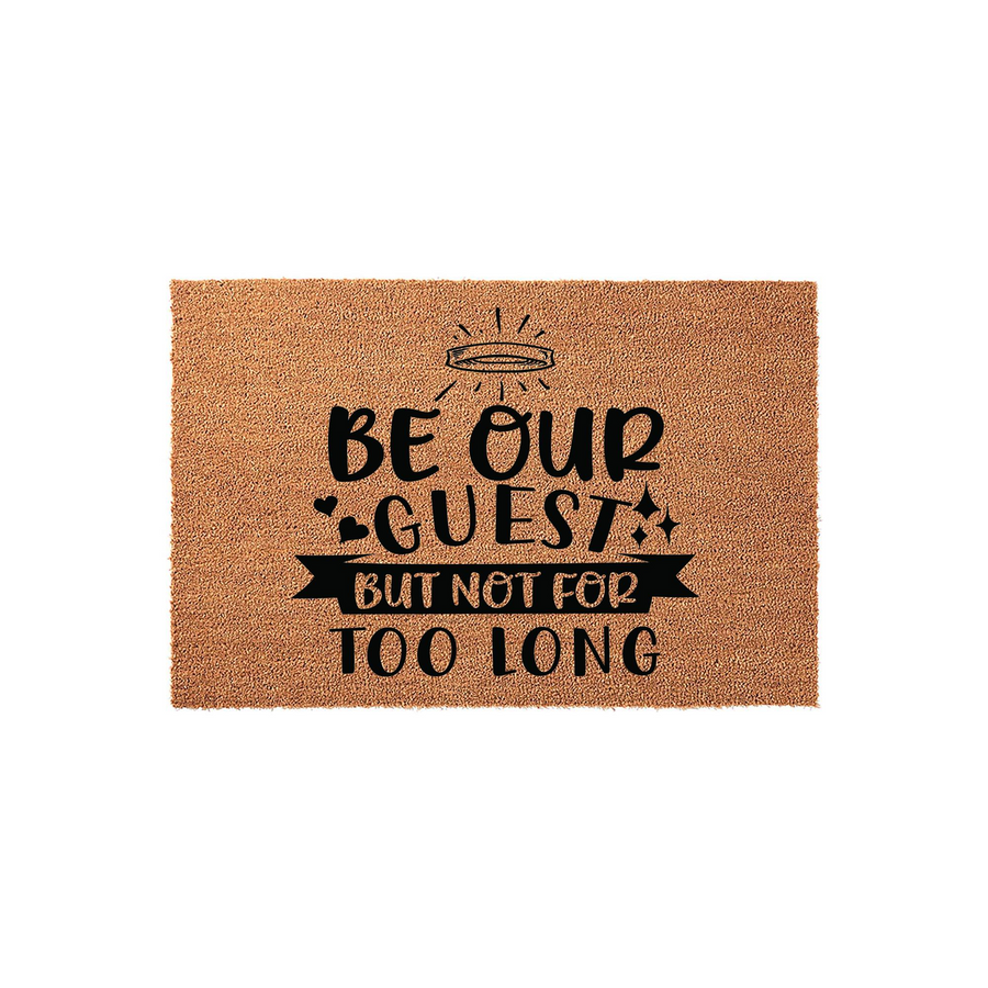 Funny Be Our Guest But Not For Too Long coir doormat featuring a natural brown fiber texture and bold black typography, designed as a humorous welcome mat for a front porch or entryway to greet visitors with a playful and witty