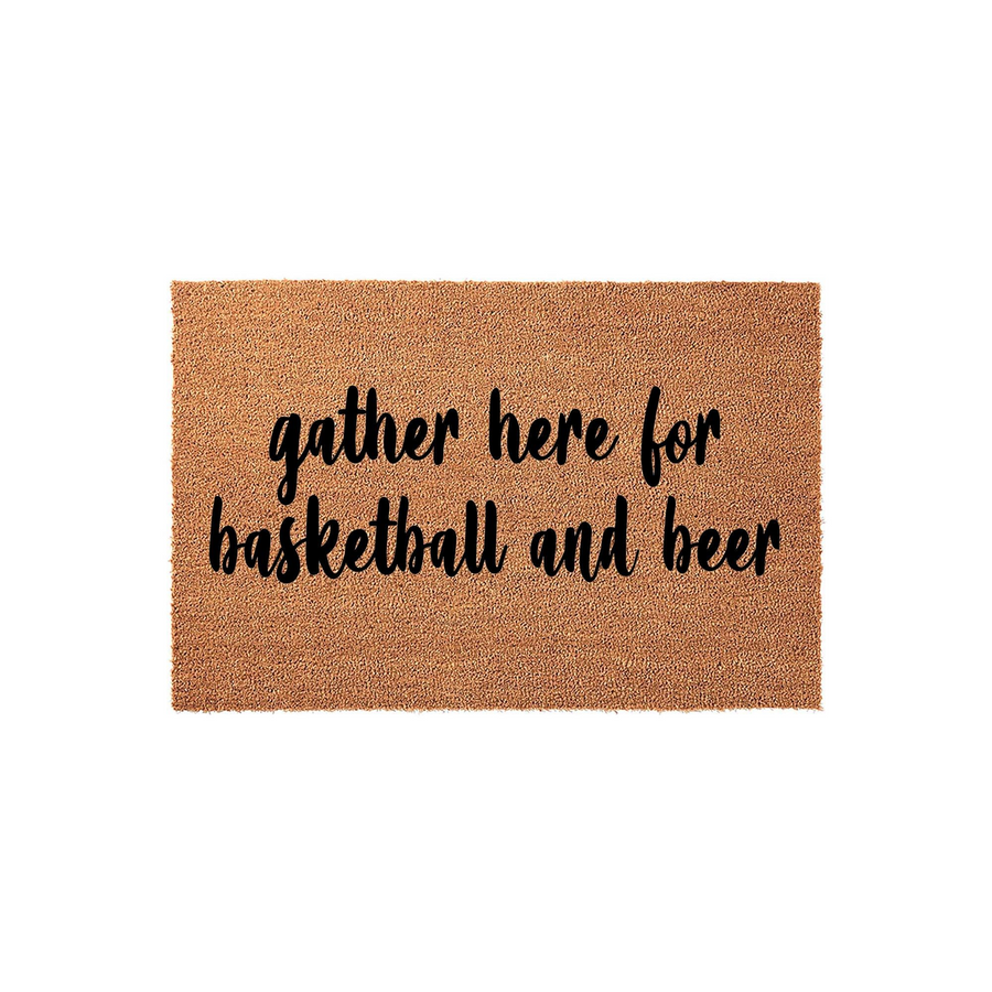 Basketball and beer coir doormat featuring a natural tan fiber texture and bold black script lettering that reads gather here for basketball and beer, making it a fun front porch decor piece for sports fans and home entertaining.