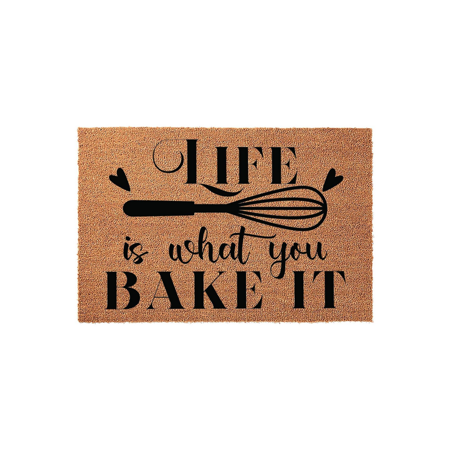 Life is what you bake it coir doormat featuring a natural brown fiber texture and black printed text with a whisk illustration, creating a charming kitchen decor accent for any home entrance or front porch area.