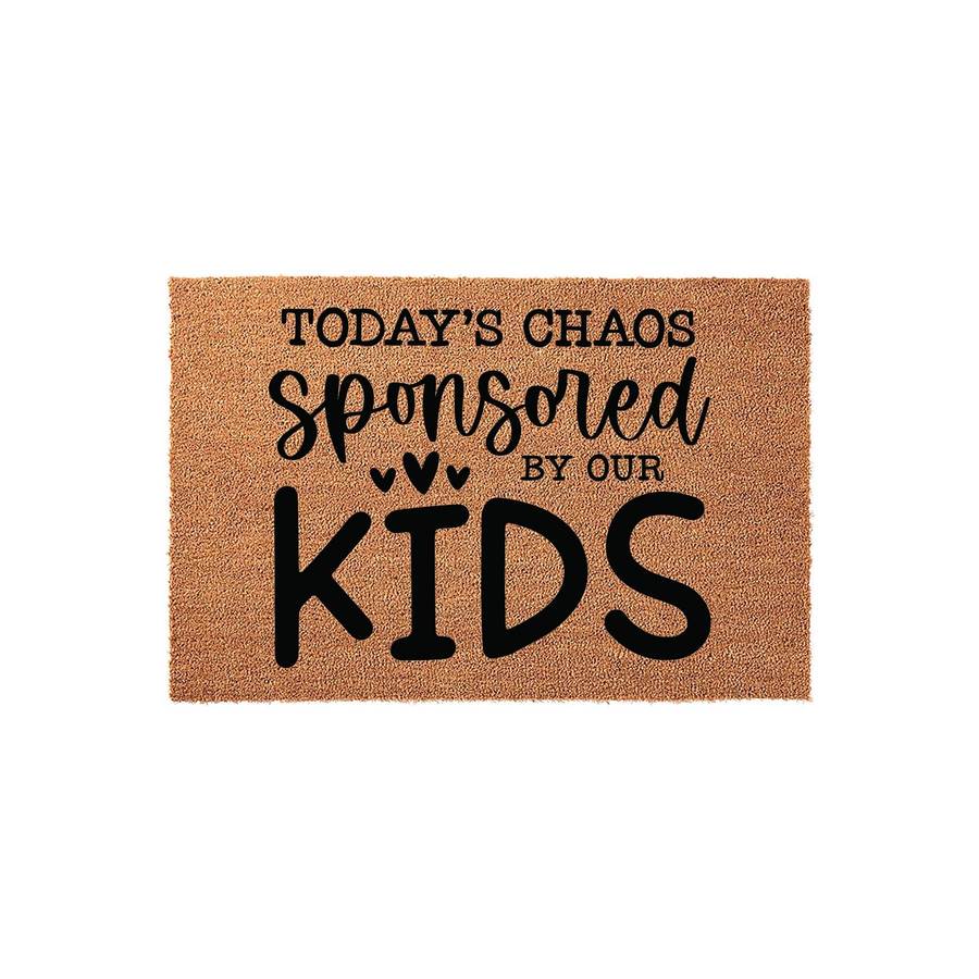Funny Today's Chaos Sponsored By Our Kids coir doormat featuring bold black typography and small heart icons on a natural brown fiber background, making it a humorous welcome mat for a busy family home entrance or front porch