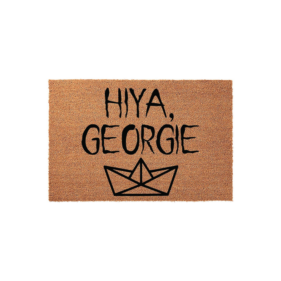 Horror movie inspired coir doormat featuring the text Hiya Georgie in a bold black font above a simple line drawing of a paper boat, set against a plain white background for a clean and spooky entryway decor aesthetic for fans.