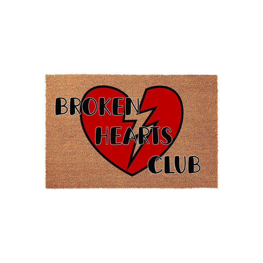 Broken Hearts Club coir doormat featuring a large, vibrant red broken heart graphic with a jagged lightning bolt center, set against a natural tan textured fiber background for a bold and modern entryway decor statement.