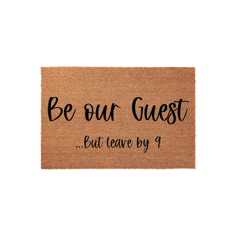 Funny Be Our Guest But Leave By 9 coir doormat featuring bold black script lettering on a natural brown coconut fiber background, providing a humorous and welcoming touch to your front porch entryway decor for guests and visitors.