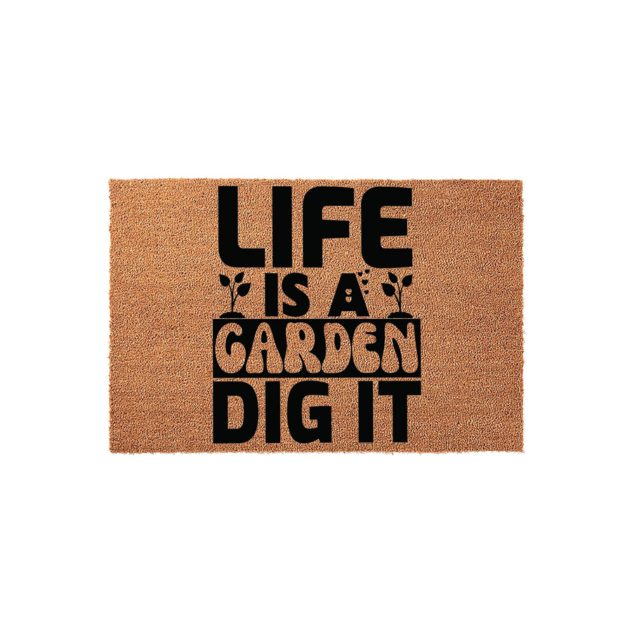 Life Is A Garden Dig It coir doormat featuring bold black typography printed on a natural tan fiber background, creating a fun and welcoming outdoor entrance decor piece for any gardening enthusiast or plant lover to enjoy at