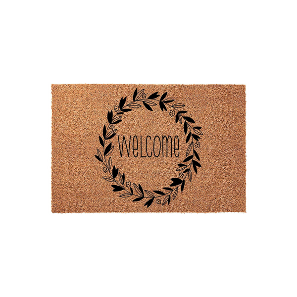 Floral Welcome Doormat featuring a natural coir fiber texture with a black ink design of a circular leaf wreath surrounding the word Welcome in a modern script font, centered on a clean white background for a farmhouse entryway.