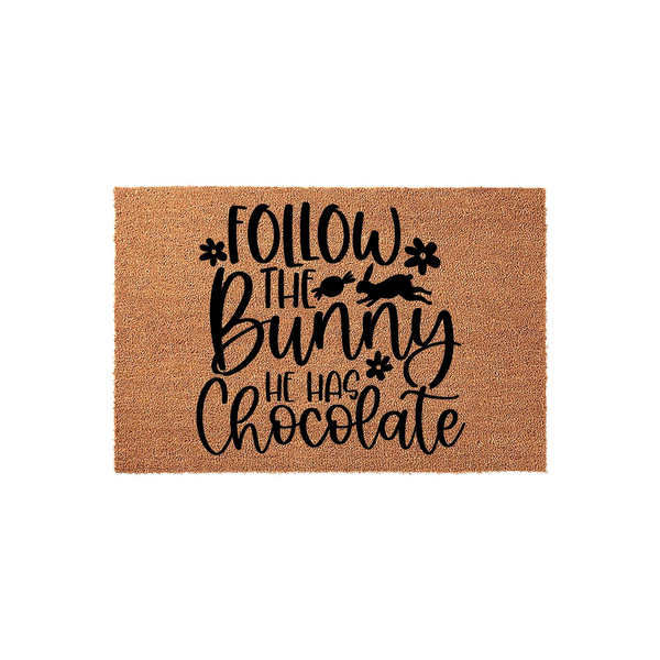 Follow the Bunny He Has Chocolate Easter doormat featuring a natural coir fiber texture with black printed text, a leaping rabbit silhouette, and small flower accents for a festive spring porch decor addition to your home