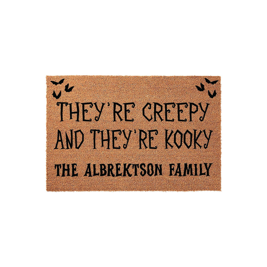 Personalized Halloween doormat featuring a natural coir texture with black text that reads They Are Creepy And They Are Kooky, customized with a family name, and decorated with small black bats in the top corners for a spooky