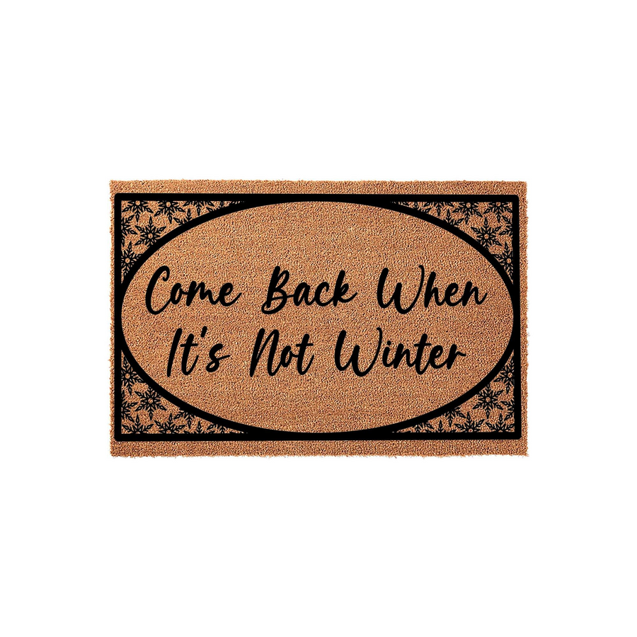 Come Back When It's Not Winter coir doormat featuring a natural brown fiber texture, an oval black border, and decorative snowflake patterns in the corners to create a festive seasonal entryway decor piece for your front porch.