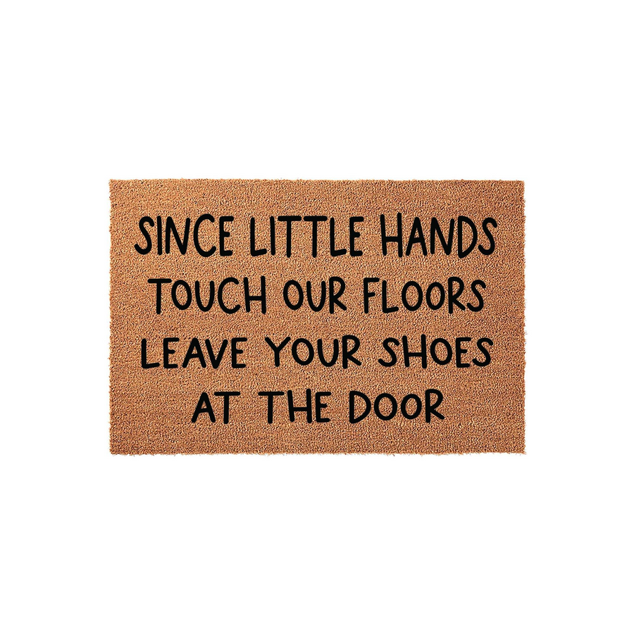 Natural coir fiber doormat featuring the black printed text Since Little Hands Touch Our Floors Leave Your Shoes At The Door, providing a functional and humorous way to keep your home clean while welcoming guests to your front