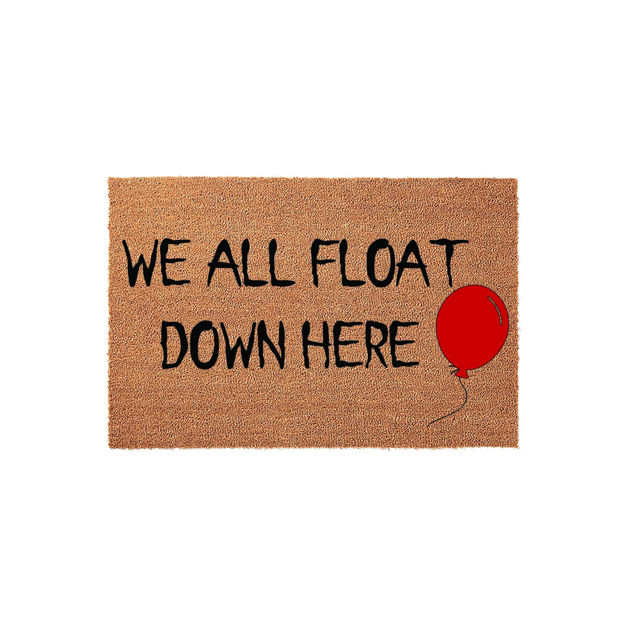 Horror movie themed coir doormat featuring the quote We All Float Down Here in bold black lettering, accompanied by a single red balloon illustration on a natural brown fiber background for a spooky Halloween entryway decoration.