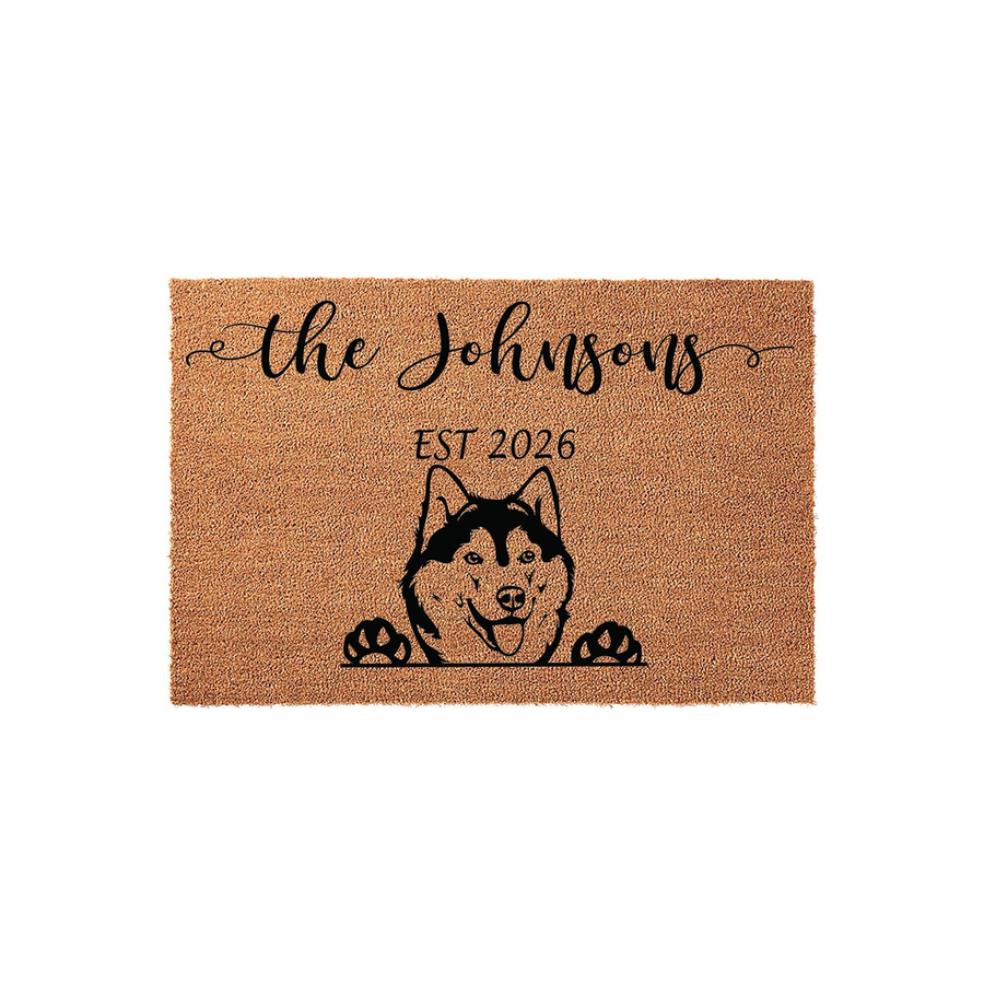 Personalized Husky Dog Coir Doormat featuring a cute illustration of a Siberian Husky peeking over the edge, customized with a family name and established year printed in elegant black script on a natural tan fiber background.