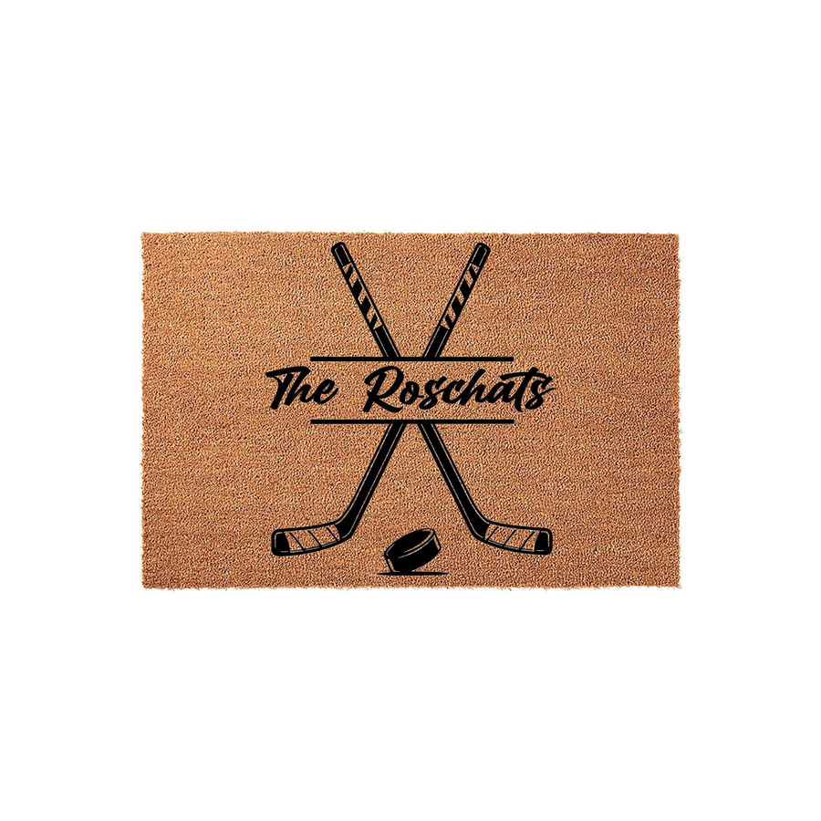 Personalized hockey family name doormat featuring a pair of crossed hockey sticks and a puck printed in black on a natural coir fiber mat, creating a sporty entrance decor piece for any hockey fan home or sports enthusiast front