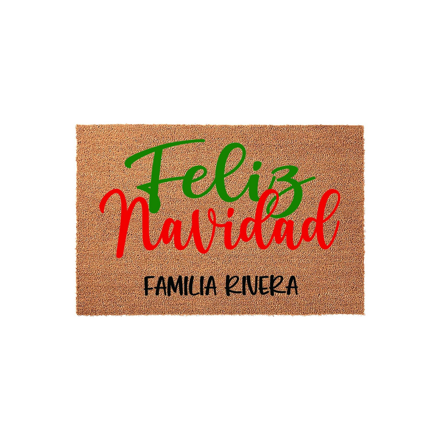 Personalized Feliz Navidad coir doormat featuring festive red and green script lettering on a natural brown fiber background, customized with a family name at the bottom to welcome guests to your home during the holiday season.