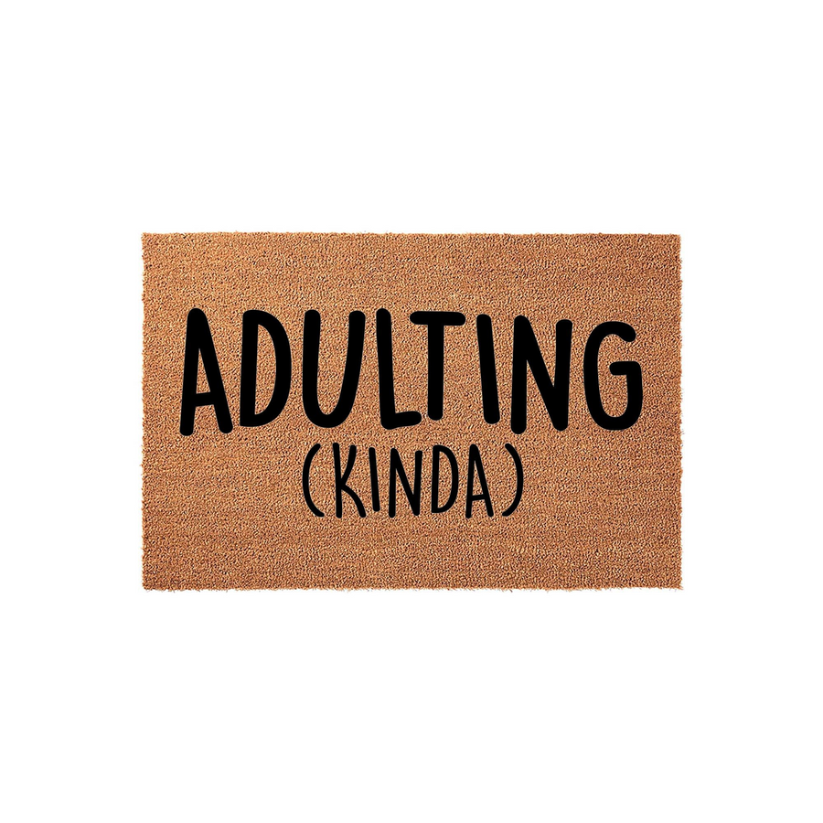 Adulting Kinda Coir Doormat featuring a natural brown coconut fiber texture with bold black lettering centered on the mat, creating a humorous and welcoming entrance piece for any home or apartment entryway on a clean white