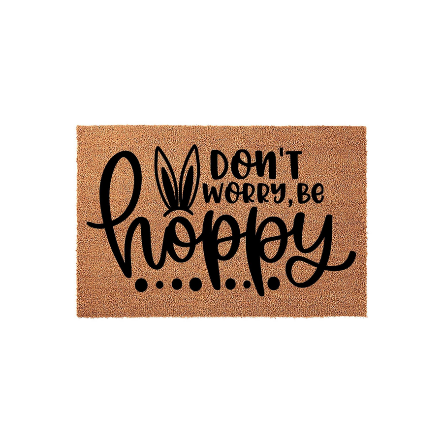 Don't Worry Be Hoppy Easter doormat featuring a natural coir texture with bold black text and cute bunny ears replacing the letter o, making a festive spring welcome mat for your front porch decor during the holiday season.