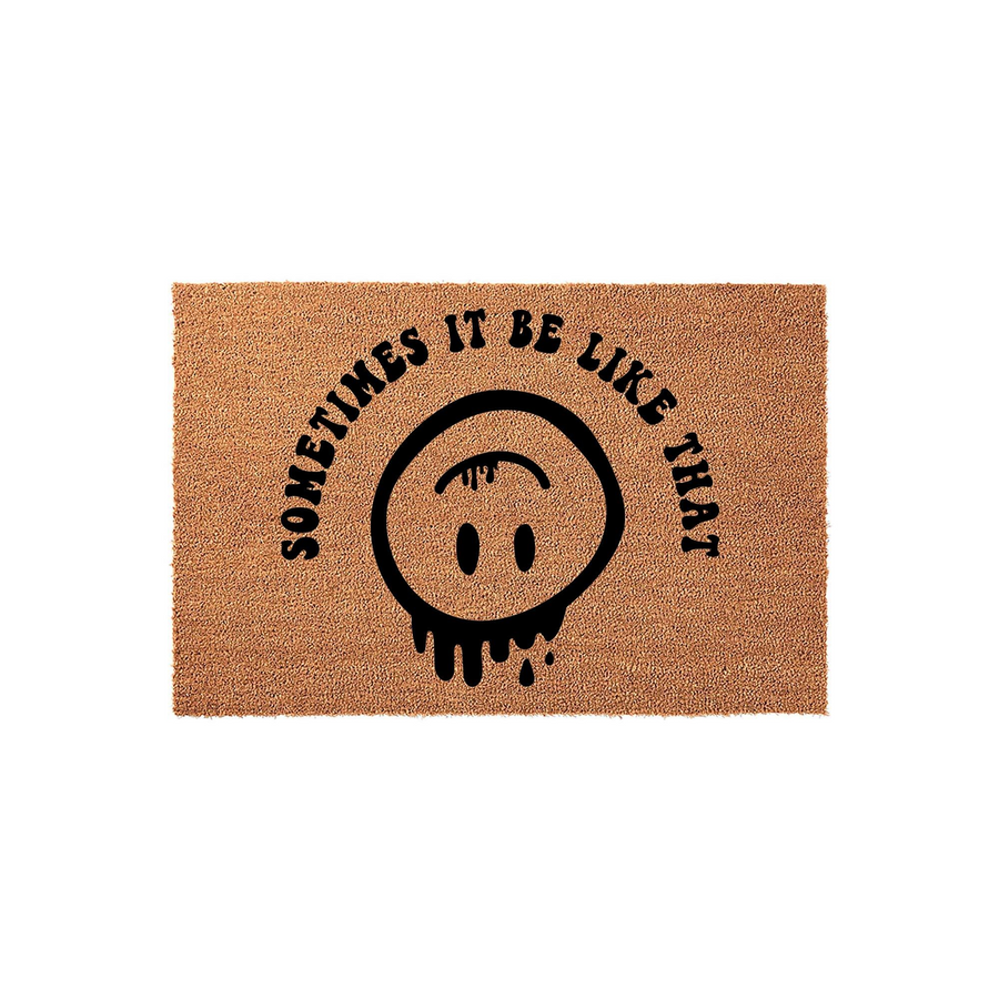 Sometimes It Be Like That Coir Doormat featuring a black printed design of a melting, upside-down smiley face, set against a natural brown textured fiber background for a fun and quirky entryway decor piece for your home.