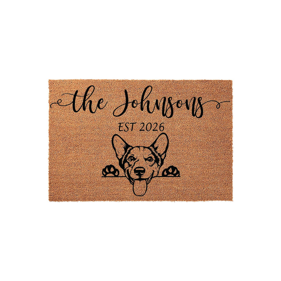 Personalized Corgi Welcome Doormat featuring a cute illustrated Corgi dog peeking over the bottom edge, with custom family name text and established year printed in black ink on a natural brown coir fiber mat against a plain