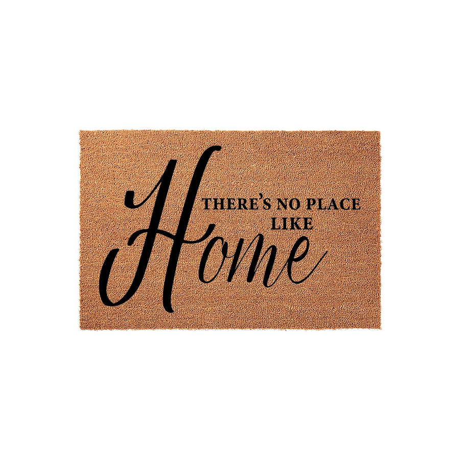 There's No Place Like Home coir doormat featuring a natural brown fiber texture and elegant black script lettering, providing a welcoming and rustic touch to any front porch or entryway decor for a cozy housewarming aesthetic.