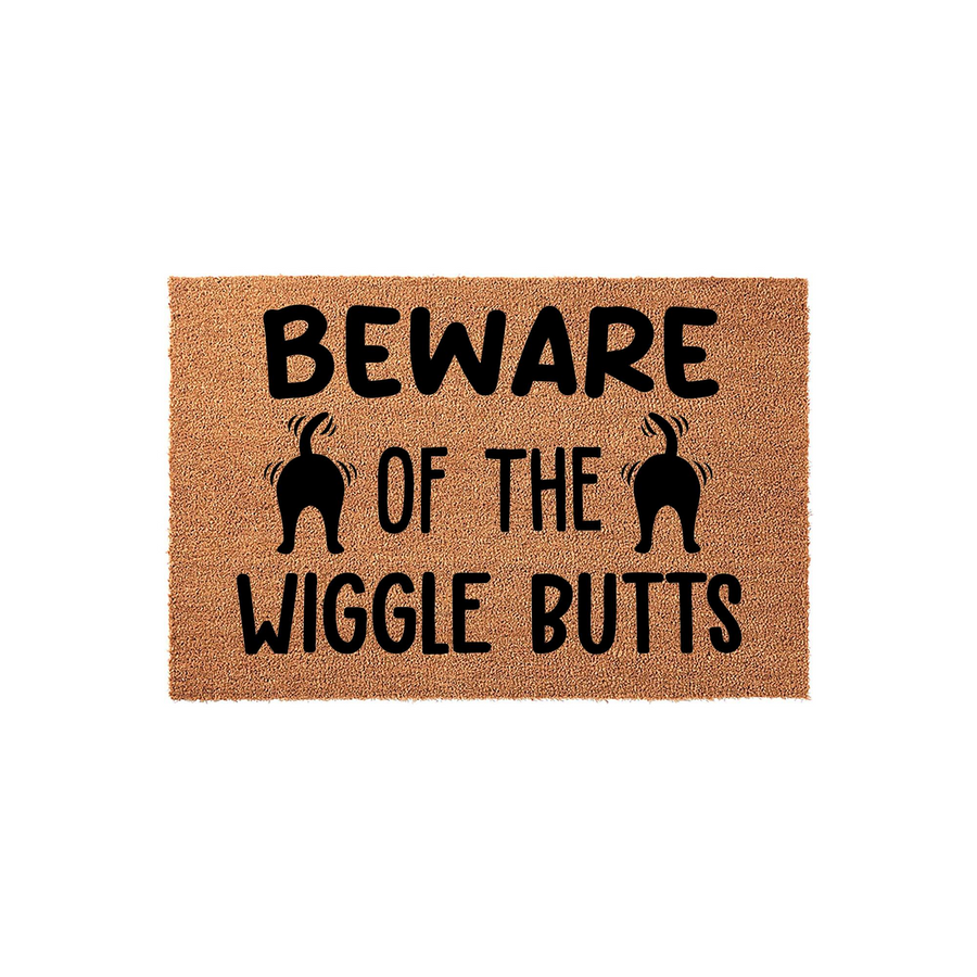 Beware of the Wiggle Butts coir doormat featuring a natural tan fiber texture and bold black text with two cute dog rear silhouettes, making it a fun and welcoming front porch decor piece for any dog lover's home entrance.