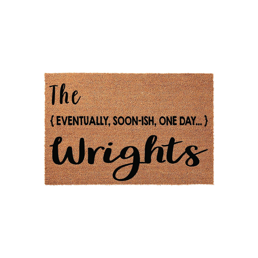 Personalized coir doormat featuring a humorous custom family name design with the text The eventually, soon-ish, one day... family name printed in bold black script and sans-serif fonts against a natural brown textured coconut