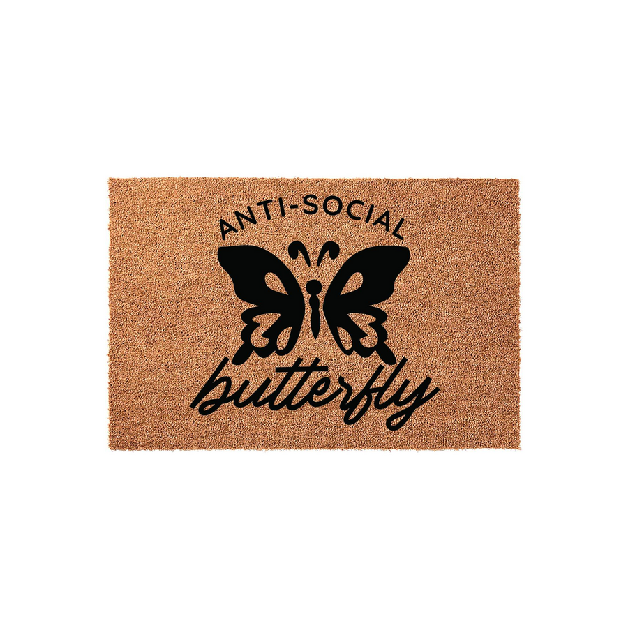 Anti-Social Butterfly Coir Doormat featuring a bold black graphic of a butterfly centered on a natural brown textured fiber background, with the text Anti-Social printed above and the word butterfly written in a cursive script