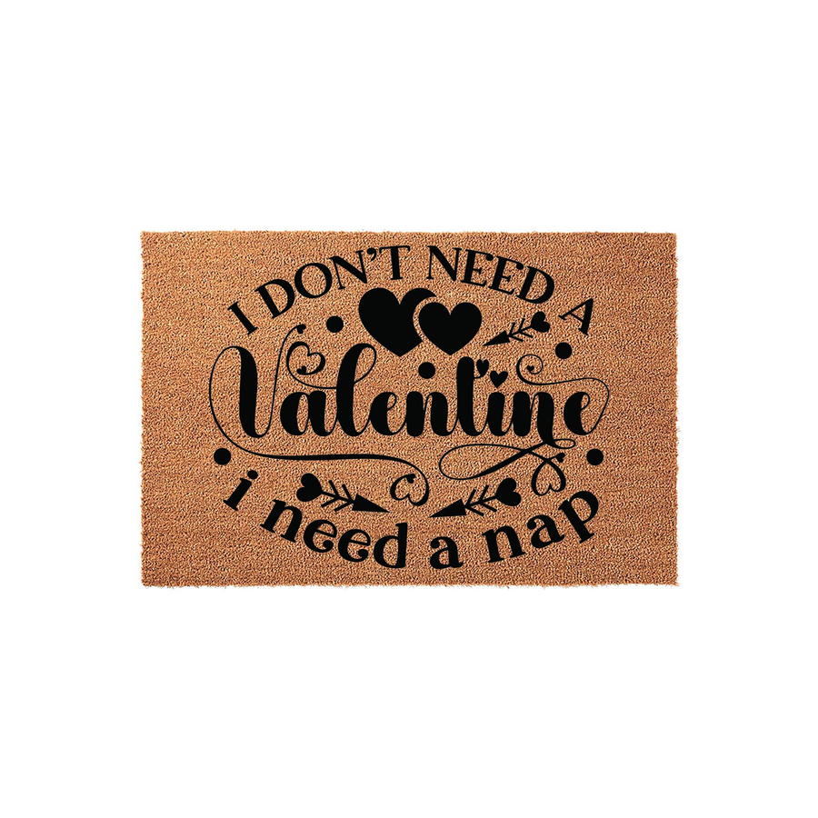 Funny Valentine doormat made of natural coir fiber featuring the black printed text I don't need a Valentine I need a nap, decorated with heart and arrow graphics on a plain white background for a humorous holiday home entrance