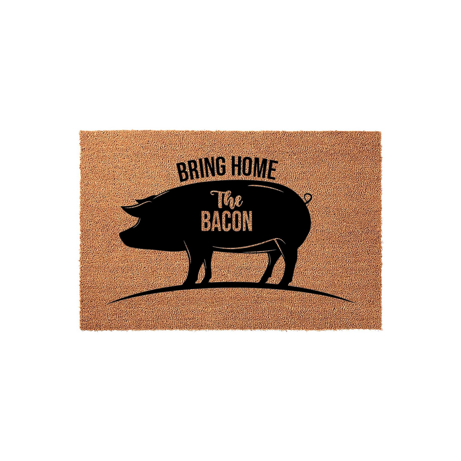 Bring Home The Bacon pig doormat featuring a natural coir fiber texture and a bold black silhouette of a pig with the humorous text printed in the center, making it a fun and rustic addition to any farmhouse style front porch