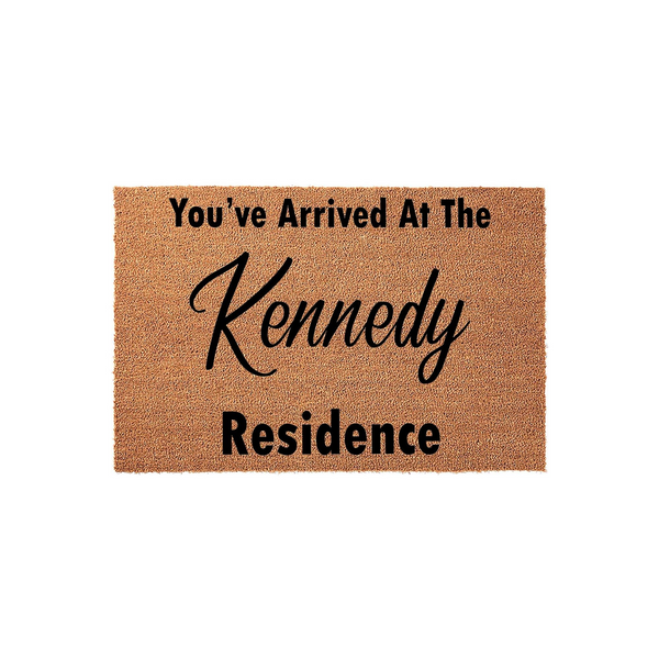 Personalized family name coir doormat featuring the text You've Arrived At The Residence in a mix of bold block and elegant script fonts, set against a natural brown textured fiber background for a classic front porch entryway