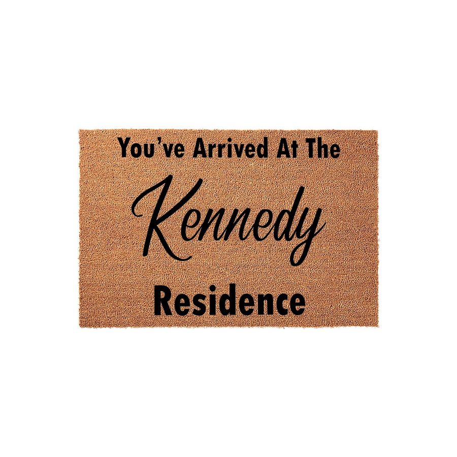 Personalized family name coir doormat featuring the text You've Arrived At The Residence in a mix of bold block and elegant script fonts, set against a natural brown textured fiber background for a classic front porch entryway