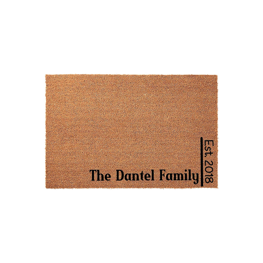 Personalized family name coir doormat featuring a natural brown fiber texture with black printed text that displays a custom family name and an established year, creating a welcoming entrance for any home on a clean white