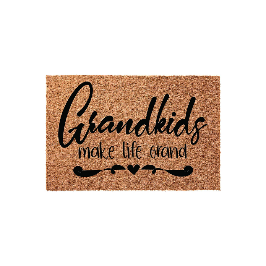 Grandkids Make Life Grand coir doormat featuring bold black script lettering on a natural tan fiber background, accented with a decorative flourish and a small heart design for a welcoming entryway decor piece.