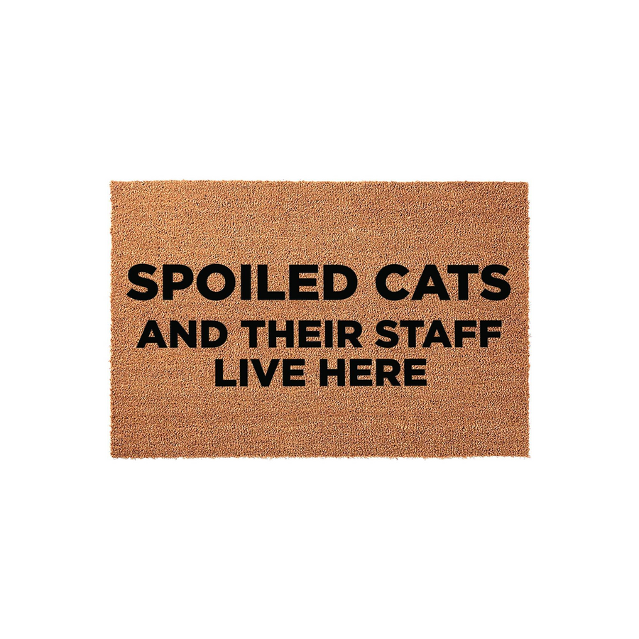 Spoiled Cats and Their Staff Live Here coir doormat featuring bold black text printed on a natural brown fiber background, making it a funny and welcoming front porch decor piece for any cat lover who enjoys a humorous home