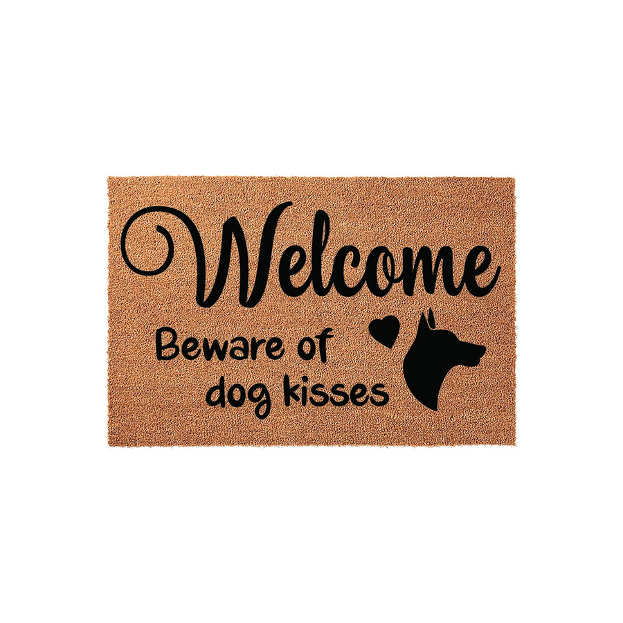 Doberman Pinscher Welcome Doormat featuring a natural coir texture with black printed text that reads Welcome Beware of dog kisses, accompanied by a silhouette of a Doberman dog head and a small heart icon on a plain white
