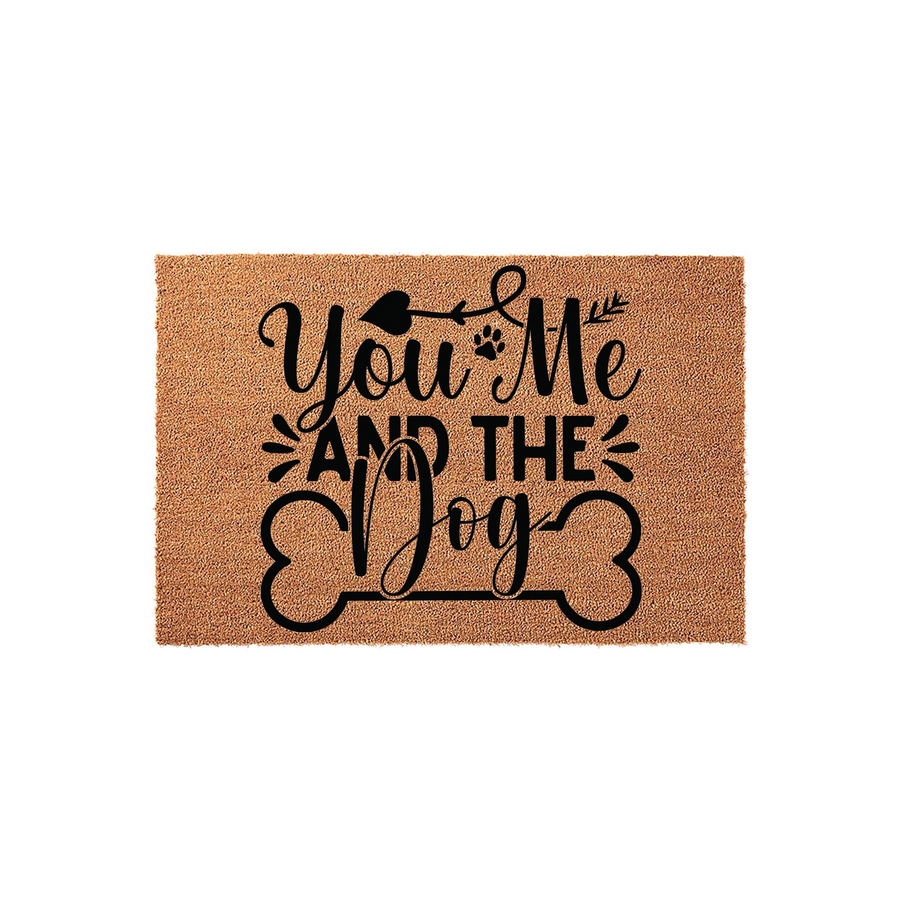 You Me and the Dog coir doormat featuring black text and a bone graphic on a natural tan fiber background, creating a charming entryway accent for pet owners who want to celebrate their furry family members at their front door.