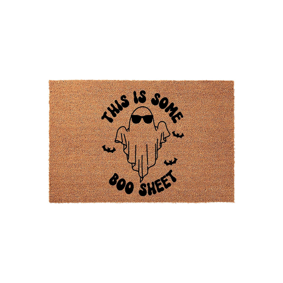 Funny Halloween doormat featuring a cute ghost wearing sunglasses with the text This Is Some Boo Sheet printed in black ink on a natural brown coir fiber background, creating a playful seasonal entryway decor piece for your front