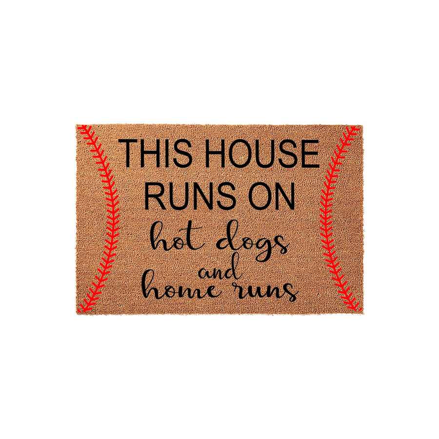 Baseball themed coir doormat featuring a red stitched ball design on the sides and the text This House Runs On Hot Dogs And Home Runs printed in black, making it a fun outdoor entrance rug for any sports fan home.