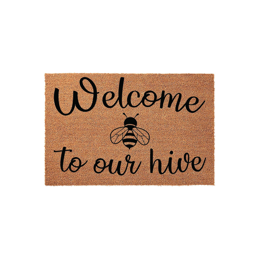 Bee Themed Welcome To Our Hive Doormat featuring a natural coir texture with black script lettering and a central bumblebee illustration, creating a charming and rustic entryway decor piece for any home front porch or doorstep.