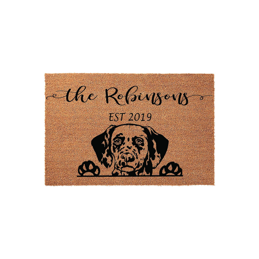 Personalized Dalmatian dog doormat featuring a natural coir texture with a black printed illustration of a Dalmatian peeking over the bottom edge, customized with a family name and established year on a plain white background.