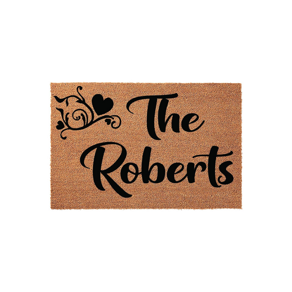 Personalized family name coir doormat featuring a rustic brown texture with black script text that reads The Roberts, accented by a decorative flourish and heart design on a clean white background for a welcoming home entrance.