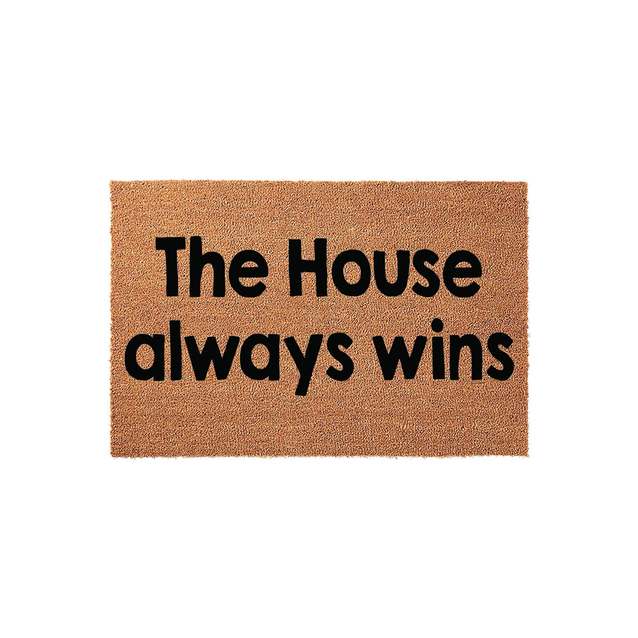 The House Always Wins coir doormat features a natural tan fiber texture with bold black lettering centered on the mat, creating a fun and welcoming entrance piece for any home front porch or entryway decor.