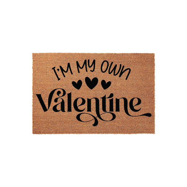 I'm My Own Valentine coir doormat featuring bold black text and three small hearts printed on a natural tan fiber background, creating a fun and festive entryway decor piece for the holiday season on a clean white studio backdrop.