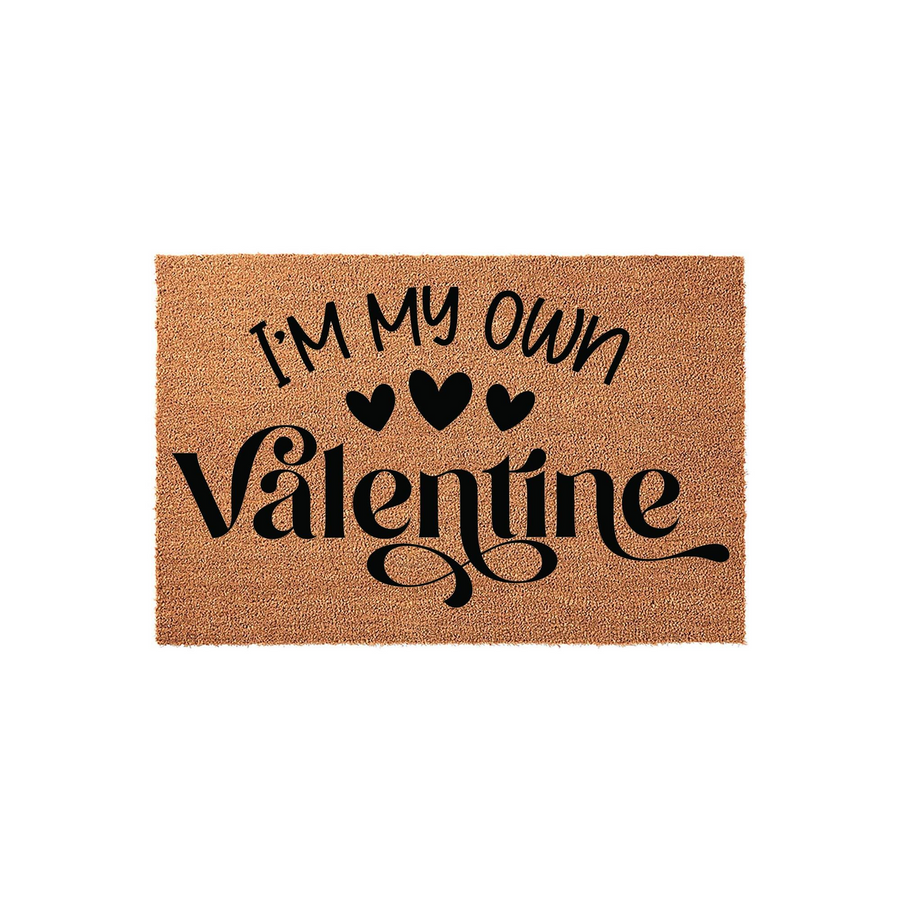 I'm My Own Valentine coir doormat featuring bold black text and three small hearts printed on a natural tan fiber background, creating a fun and festive entryway decor piece for the holiday season on a clean white studio backdrop.